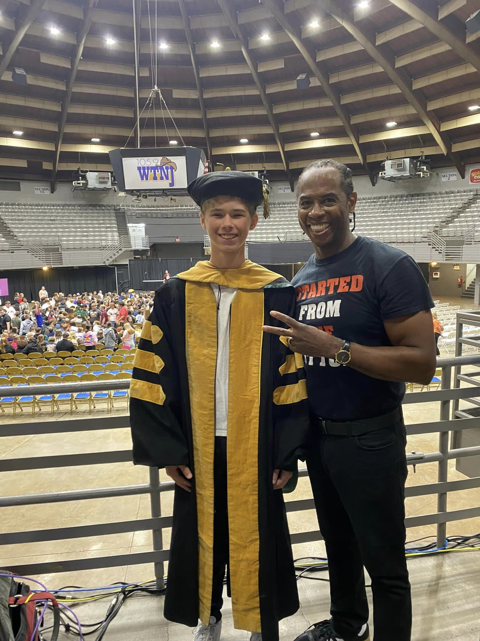 Male student standing next to a man smiling