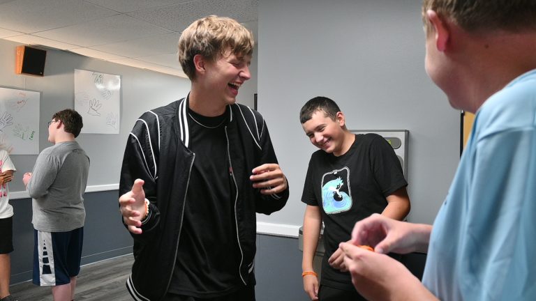 boys laughing in a hallway with gray walls