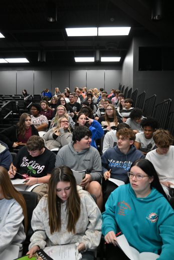 Students sit and converse about finances during a financial literacy session with MJ Bridges.