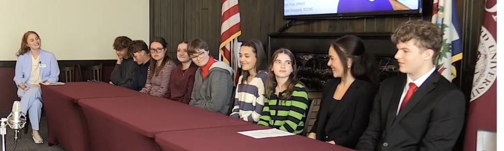 Students sitting at a table for a panel discussion